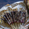 arrosticini cuites avec ciabatta à côté sur fond de bois