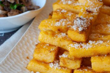 galettes de polenta sur une assiette blanche saupoudrées de sucre