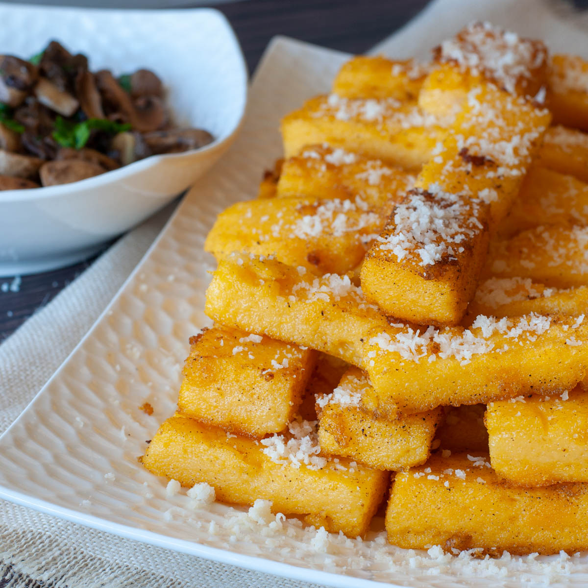 galettes de polenta sur une assiette blanche saupoudrées de sucre