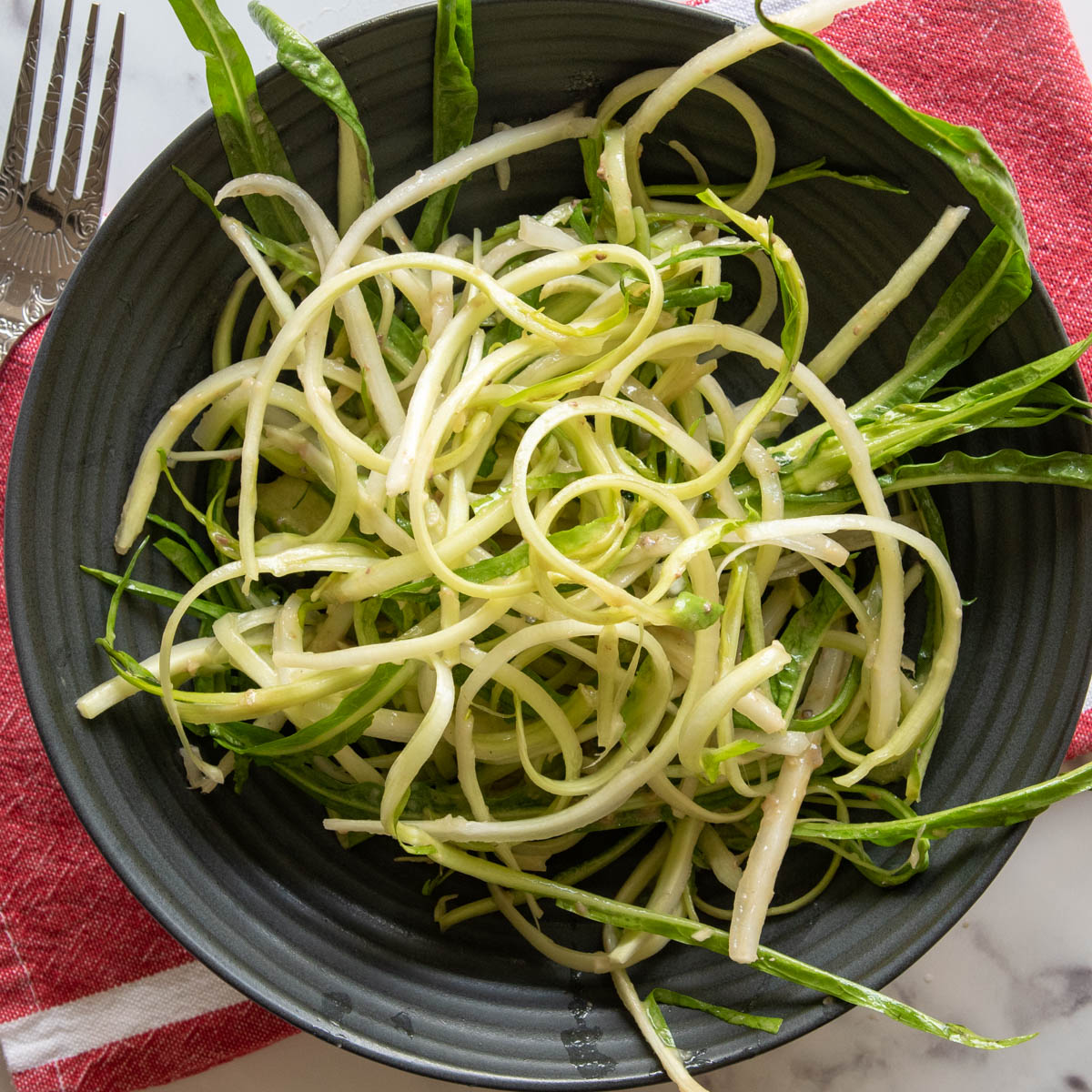 salade de puntarelle italienne sur assiette noire