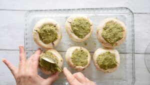 Champignons italiens farcis au four, faciles, avec pistaches - - Garnissez chaque chapeau de champignon avec la farce, en tassant délicatement pour que la garniture reste bien en place