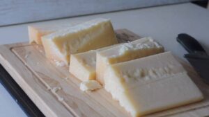 Comment préparer de la chapelure italienne - Coupez le parmesan en morceaux afin qu'il s'adapte à l'ouverture de la râpe