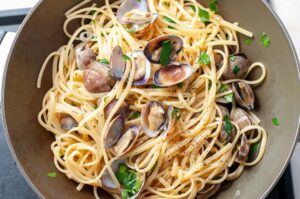 Linguine alle vongole italiennes aux palourdes fraîches - Remettez les palourdes et le jus filtré dans la poêle