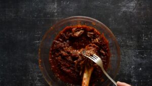 Ragoût de jarret d'agneau braisé - Disposez le ragoût d'agneau dans un plat de service et retirez la viande de l'os. Elle sera très tendre