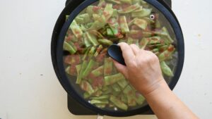 Recette Facile et Authentique de Haricots Verts à l’Italienne avec Tomates - Réduisez le feu et laissez mijoter les haricots verts à couvert afin de développer les saveurs