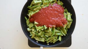 Recette Facile et Authentique de Haricots Verts à l’Italienne avec Tomates - Versez délicatement la sauce tomate dans la poêle en prenant garde aux éclaboussures éventuelles dues à l'huile chaude