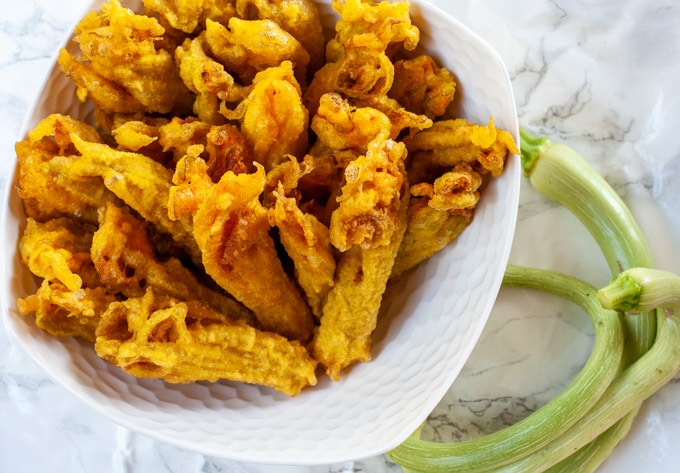 L’incontournable beignet de fleurs de courgette, un délice croustillant qui sublime la fraîcheur du potager.