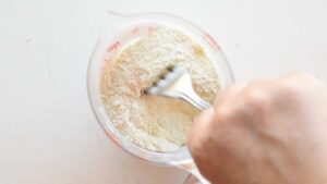 Recette de Friselle Pugliesi Maison - Mélangez la levure avec le reste de la farine puis ajoutez-les à la pâte
