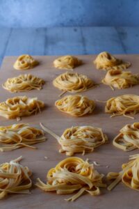 Recette de pâtes italiennes maison - Déposez chaque portion de tagliatelles sur le plan de travail fariné