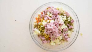 Recette de salade de riz Insalata Di Riso - Dans un grand saladier, mélangez le riz refroidi, les légumes préparés et tout autre ingrédient supplémentaire comme des raisins secs ou des noix.