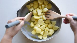 Recette facile de pommes de terre rôties croustillantes à l’italienne - Assaisonnez avec le sel et mélangez pour que les pommes de terre soient uniformément relevées par les saveurs fraîches.