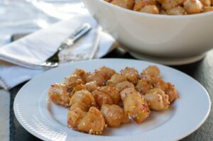 Recette traditionnelle de Struffoli au Cognac - Ajoutez des pralines colorées et laissez refroidir complètement avant de servir