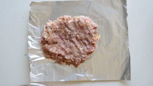 Recette traditionnelle de polpettone italien (Pain de viande italien) - Sur une surface plane, façonnez la moitié de la préparation en forme de pain
