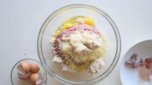 Recette traditionnelle de polpettone italien (Pain de viande italien) - Ajoutez le parmesan, râpé, et les œufs, puis assaisonnez avec du sel
