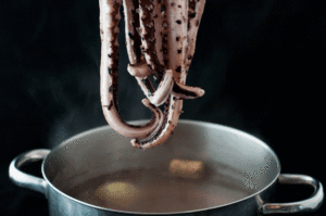 Salade de Poulpe Italienne (Insalata Di Polpo) - Lorsque l'eau bout, plongez les tentacules du poulpe dans l'eau plusieurs fois avant d'y placer le poulpe entier. Cela permet de faire friser les tentacules pour une meilleure présentation.