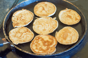 Blinis salés à servir lors d'un dîner - cuisson des pancakes à la poêle