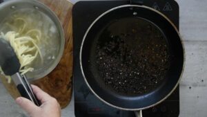 Cacio e pepe (tonnarelli au fromage et au poivre noir) - sortir les pâtes de l'eau