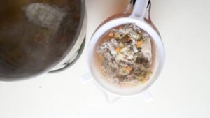 Comment préparer un consommé de bœuf - premier filtrage à la passoire
