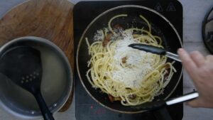 Les pâtes alla gricia préparées à Rome dans les années 70 - Incorporer le pecorino râpé