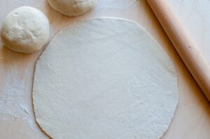 Pizza aux artichauts, tomates séchées et scamorza - Étaler la pâte finement